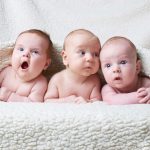 Drei Babys unter Decke